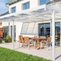 Weißes Gutta Terrassendach Premium mit Stegplatten und Sitzgruppe auf Terrasse.