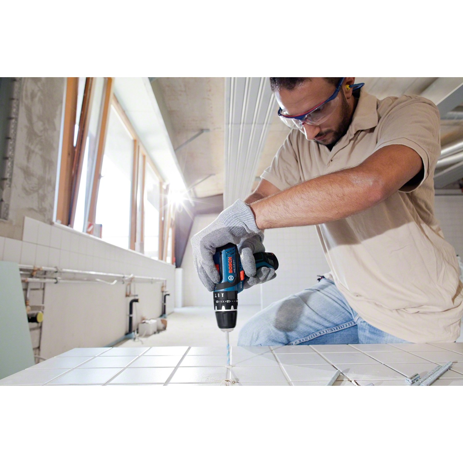 Bosch Professional Akku-Schlagbohrschrauber GSB 12V-15 in Aktion beim Bohren in Fliesen.