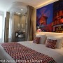 Hotelzimmer mit Grosfillex Wandpaneel GX Wall+ Creme Slate als Wanddekor mit Moulin Rouge Motiv.