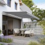 Gelenkarmmarkise Aventura 4x2,5m Grau-Weiß über Terrasse mit Tisch und Stühlen.