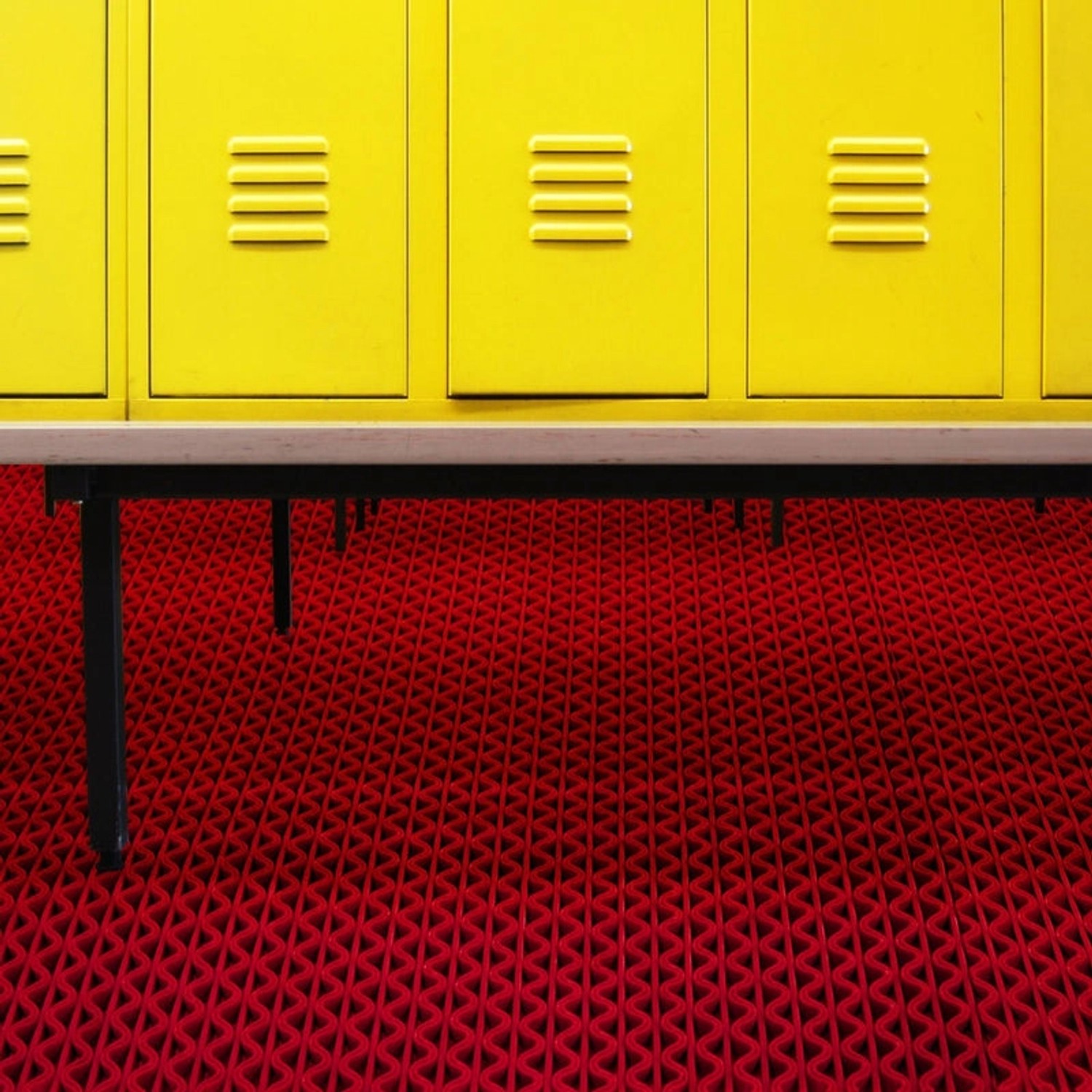 Rote KARAT Hygienematte für Barfußzonen vor gelben Spinden. Poolumrandung mit UV-Schutz, 90x1000 cm.