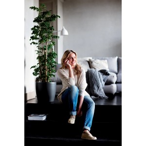 Anthrazitfarbener Elho Blumentopf Brussels Rund mit Rollen (Ø 35 cm) im Wohnraum mit Pflanze.