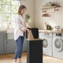 Schwarzer Songmics Wäschesammler Roxanne (90 l) mit Deckel im Badezimmer.