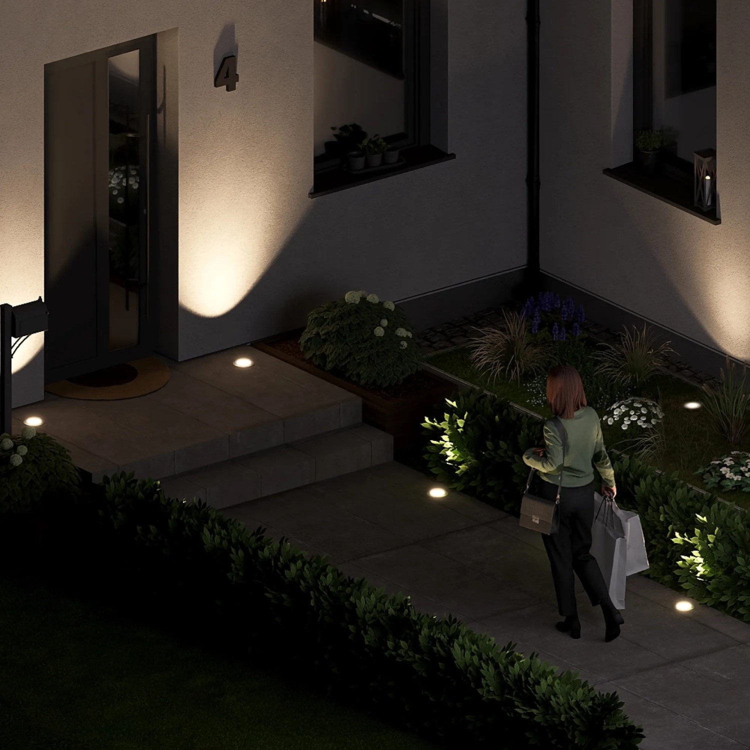 Szene mit dem SSC-LUXon 4er Set Bodenstrahler: Flache, silberne Außenleuchten beleuchten einen Hauseingang und Gartenwege.