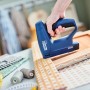 Rapid Akku-Tacker BTX10 beim Polstern eines Möbelstücks. Blauer Tacker mit Hand.
