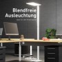 Weiße Oktaplex Malmö LED Stehlampe für Büro mit neutralweißem Licht auf einem Schreibtisch.