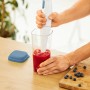 Rotho Küchenhelfer Loft: 5-in-1 Messbecher transparent mit Horizontblau Deckel und Stabmixer in Nutzung.