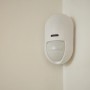 Yale Bewegungsmelder für Alarmanlage, Teil des Smart Alarm Starterkits, an einer Wand montiert.