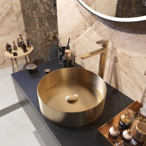 Rundes Aufsatzwaschbecken aus gold gebürstetem Edelstahl in modernem Bad. Inkl. passender Armatur auf dunkler Platte.
