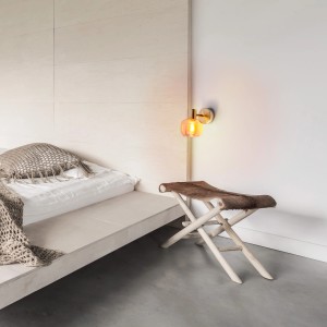 Näve Wandspot Libby Messing, amberfarbenes Glas, 16 cm, montiert an einer weißen Wand.