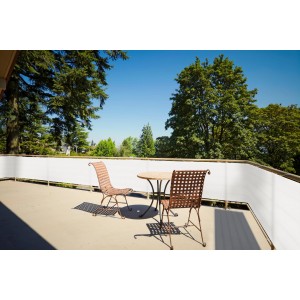 Cremeweiße HDPE Balkonumrandung 90x500 cm als Sichtschutz auf Balkon mit Möbeln.