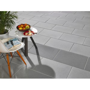 Verlegte, dunkelgraue Kann Terrassenplatte Casavera, geschliffen, 60x40x3,6 cm, mit Tisch und Stuhl.