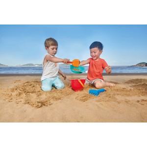 Hape Sandspielzeug Grundausstattung, 4-teilig, mit Eimer, Schaufel, Harke und Sieb am Strand.