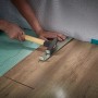 Verlegen von Laminat mit dem wolfcraft Verlege-Set: Zugeisen, Schlagholz und Keile im Einsatz.