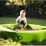 Grüner BIG Sandkasten Sandy mit Kind beim Spielen im Garten, Abdeckung teilweise geöffnet.