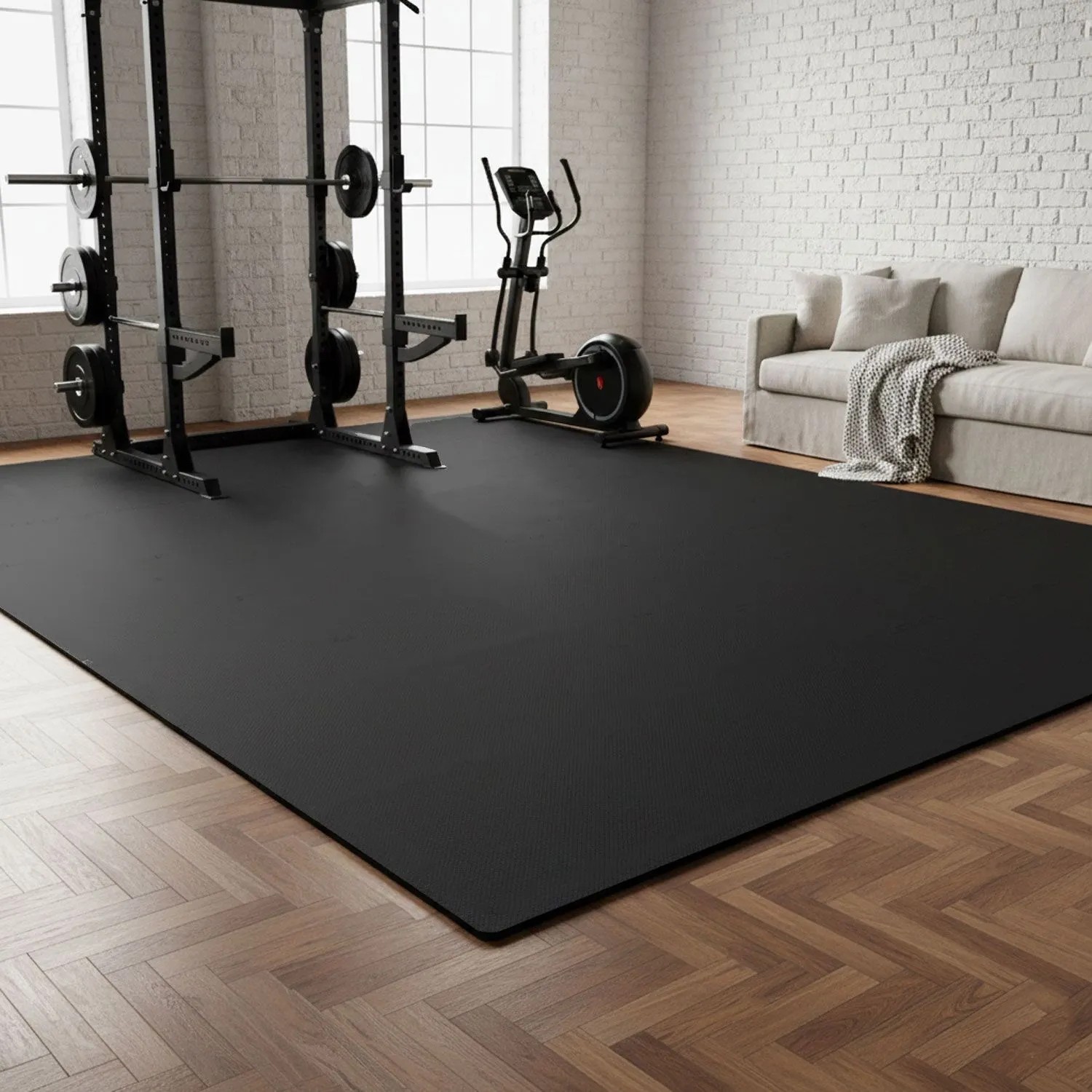 Schwarze Bodenschutzmatte im Home Gym unter Fitnessgeräten wie Hantelbank und Crosstrainer auf Parkettboden.