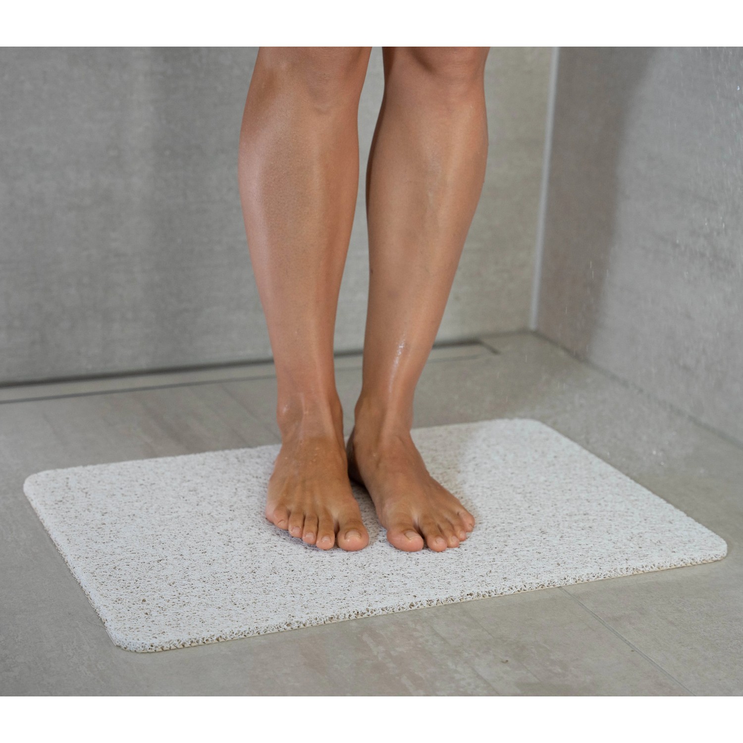Weiße baliv Duschmatte Hydro Wonder (40x60 cm) unter Füßen in Dusche. Rutschfeste Wanneneinlage für Komfort.