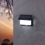 Schwarze Eglo LED Solar Wandleuchte Utrera mit Bewegungssensor an grauer Wand.