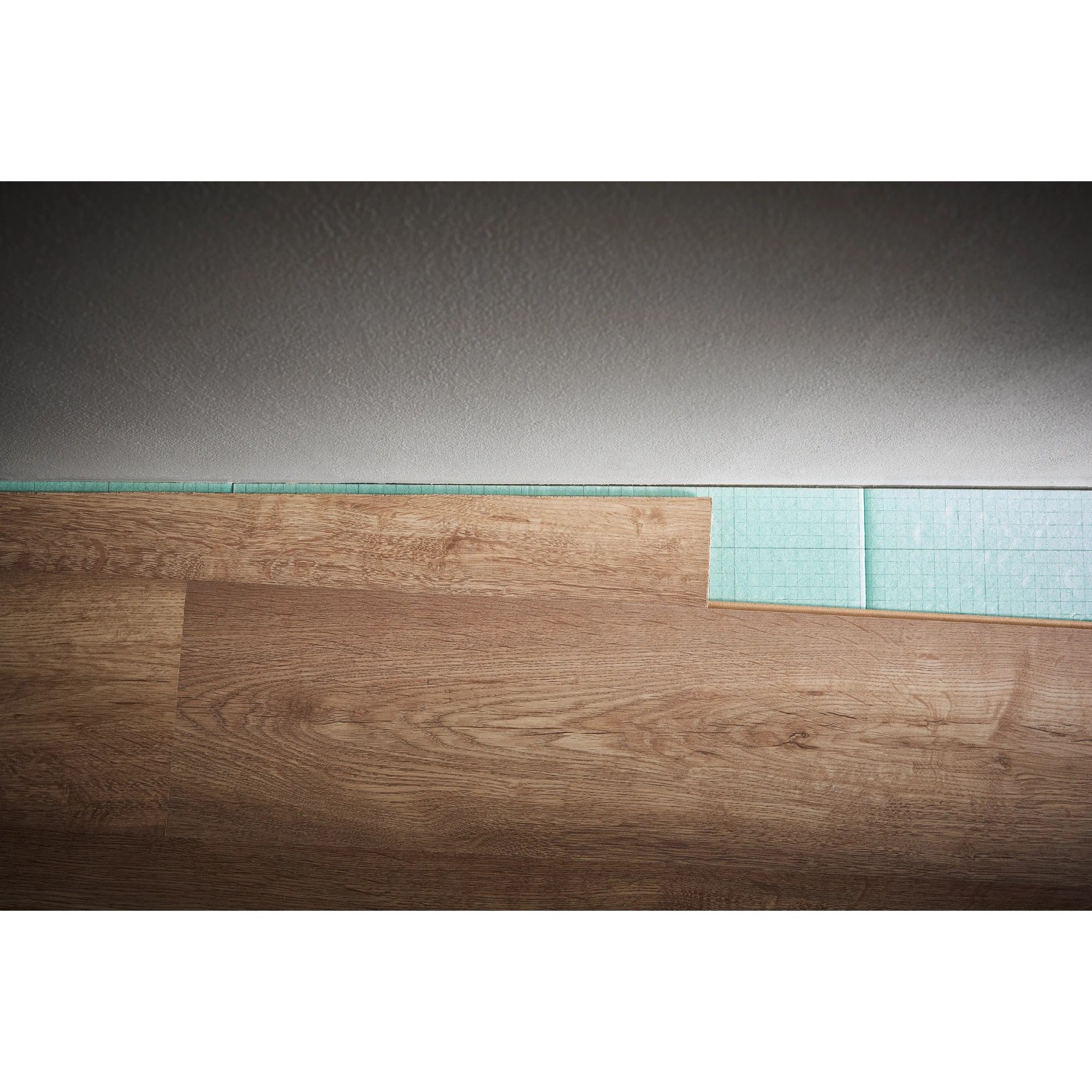 Verlegung von Laminatboden mit Trittschalldämmung. Werkzeug zum Einpassen von Laminat sichtbar.