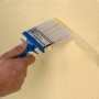 Auftragen von Knauf Easy Putz (fein) mit einem Pinsel auf eine Wand. Putz für Innen.