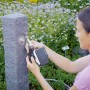 Frau installiert Geka Bewässerungscomputer am Wasserhahn im Garten.
