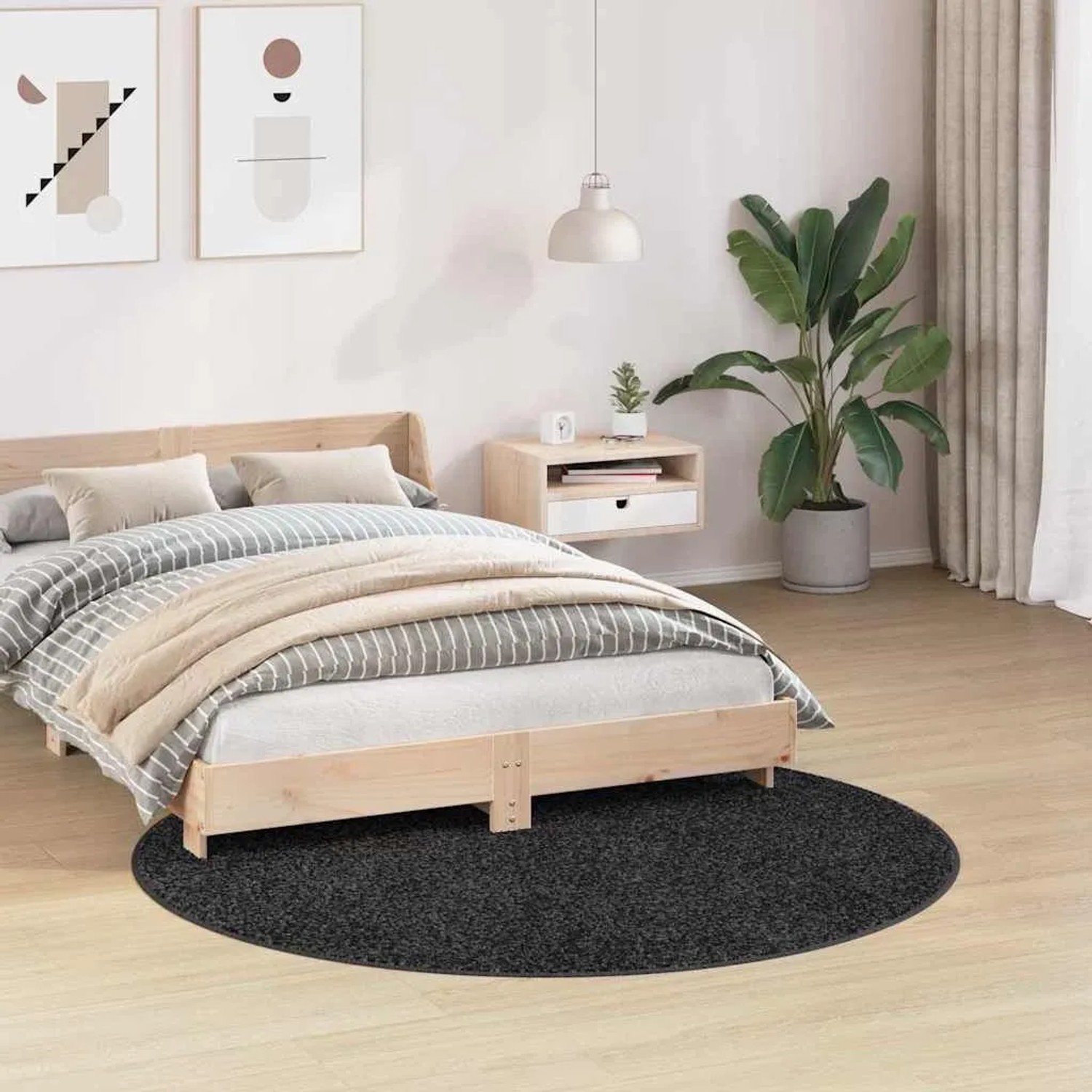 Runder, dunkelgrauer Shaggy Hochflorteppich im Schlafzimmer. Der rutschfeste Teppich liegt unter einem Holzbett.