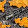 LED Akku-Taschenlampe, dimm- und zoombar, 450 Lumen, 5000K, IPX7, mit Clip auf Steinen und Blättern.