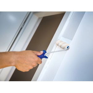 LUX Dispersionsroller 10 cm im Einsatz: Hand streicht weiße Wand mit Farbroller. Ideal für kleine Flächen.