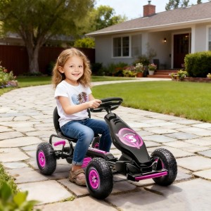 Mädchen fährt schwarzes HOMCOM Go Kart mit pinken Rädern auf gepflastertem Weg. Robustes Kinderfahrzeug aus Kunststoff/Metall für Spiel & Spaß.