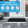 Schwarze Björn&Schiller Fußmatte mit Alu-Rahmen und Bürsten vor einer Haustür.