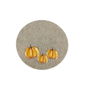 Rundes Boltze Tischset in Braun-Grau mit drei orangefarbenen Kürbis-Motiven. Geflammte Optik, aus Polyester.