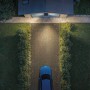 Philips Solar-LED-Außenstrahler Zyren beleuchtet Hofeinfahrt mit Auto und Haus im Hintergrund.