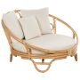 Beige Sonneninsel aus Rattan mit Kissen, ideal für den Garten.