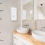 Bosch Tronic Comfort Plus Durchlauferhitzer im modernen Badezimmer mit zwei Waschbecken.