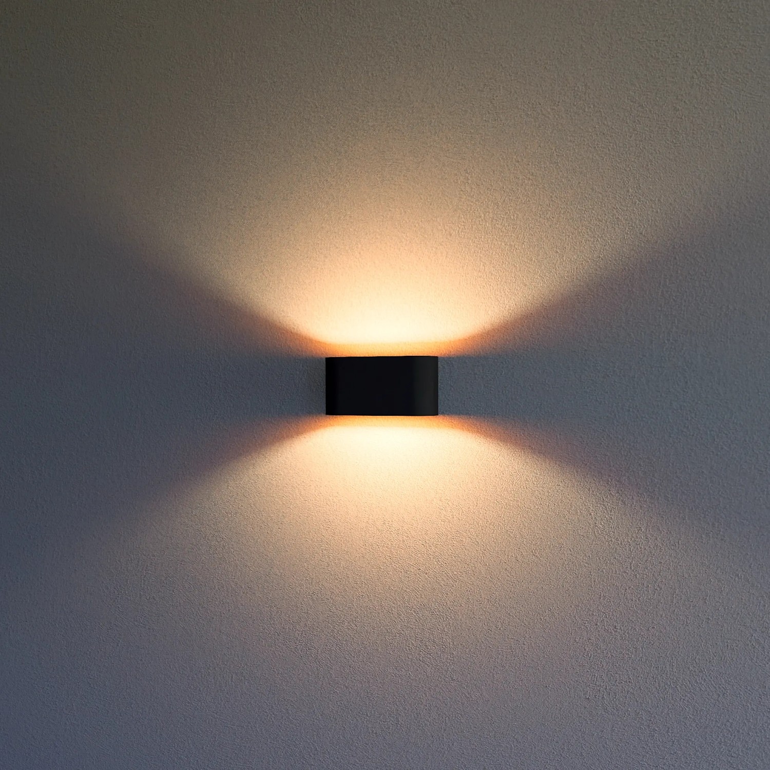 Rechteckige, schwarze Wandleuchte mit goldenem Reflektor, die warmes Licht nach oben und unten abstrahlt.