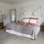 Verlegter, wasserfester Egger NatureSense Aqua Laminatboden in Grau im Schlafzimmer.