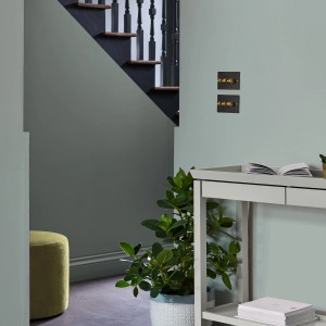 Wohnraum in Grau-Grün mit Laura Ashley Wandfarbe, Treppe und Dekoration.