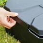 Heissner Garden Power Box, schwarze Stromverteilerbox für den Garten, wird von einer Hand geöffnet.