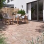 Verlegte Diephaus Terrassenplatten Nano Tec Ocker-Gelb-Rose auf einer Terrasse mit Gartenmöbeln.