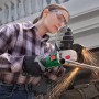 Frau schleift Metall mit Bosch Akku-Winkelschleifer PWS 18V-70. Funken fliegen.