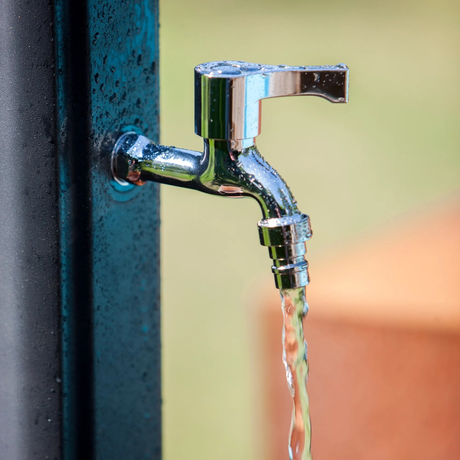 Detailaufnahme: Wasserhahn der Gre Solardusche aus Harz, Wasser läuft.