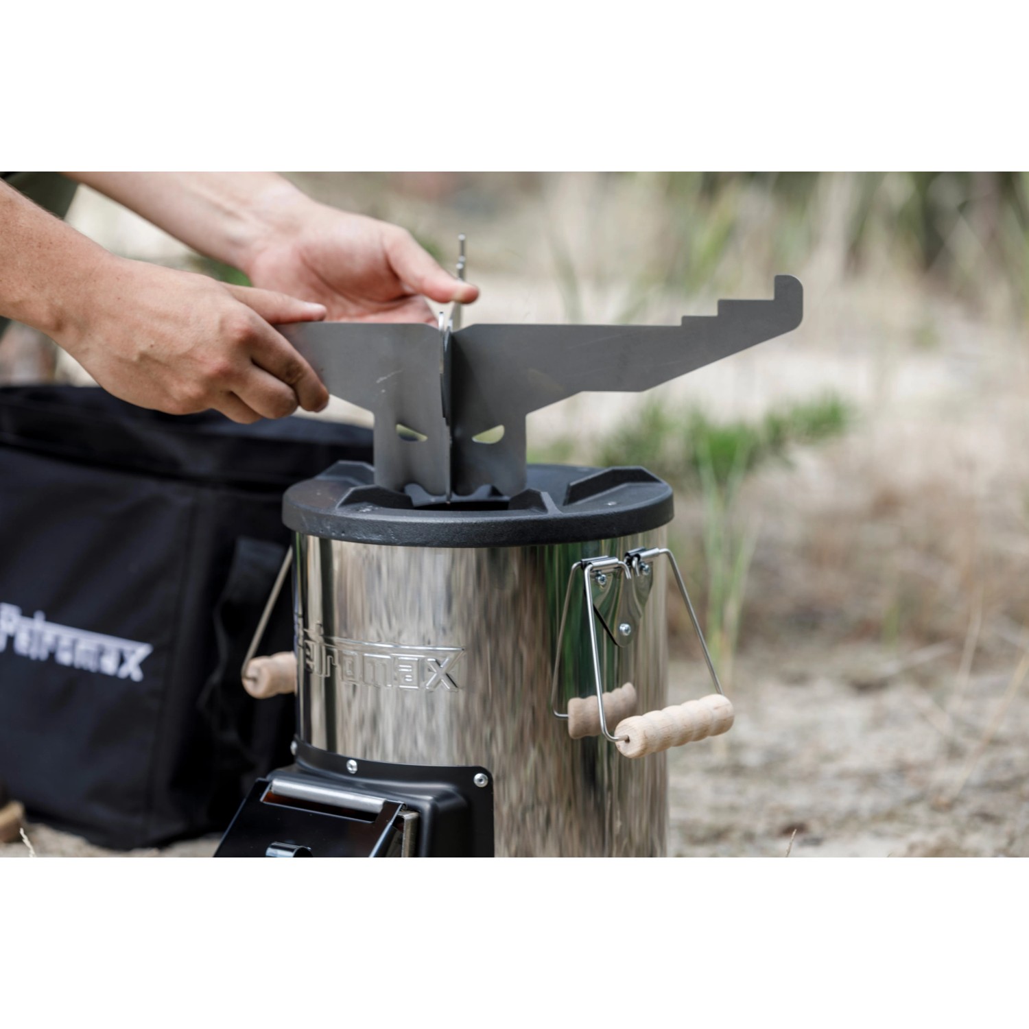 Petromax Grillplatte mit Kochkreuz wird auf Raketenofen montiert. Grillutensil für Outdoor-Küche.