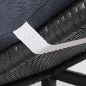 Detailaufnahme: Anthrazitfarbene Poly-Rattan Sonnenliege mit grauem Kissen und weißem Befestigungsband.