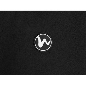 Detailansicht des runden schwarzen PU-Badges mit weißem Logo auf der schwarzen Fleece-Jacke. Zeigt die Textur des Polyester-Stoffs.