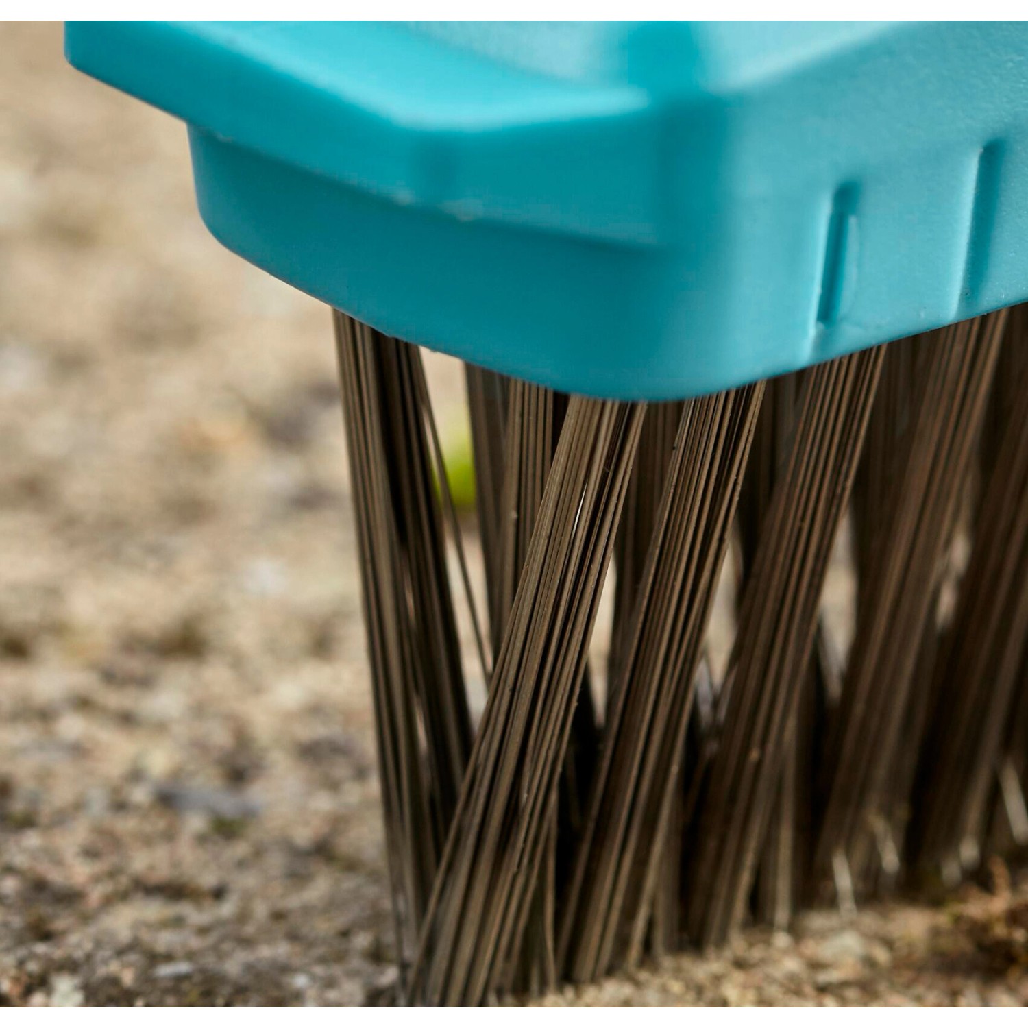 Detailaufnahme: Gardena Combisystem Fugenbürste M mit Stahlborsten und blauem Kunststoffaufsatz.