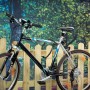 LUX Fahrrad mit Panzerkabel-Schloss (85 cm) an Holzzaun gesichert.