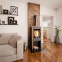Haas+Sohn Kaminofen Naturstein Schwarz 6 kW mit Automatik im Wohnraum mit brennendem Feuer.