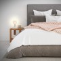 Weiße Brilo Tischleuchte Teepu mit E27 Fassung auf Nachttisch neben Bett.
