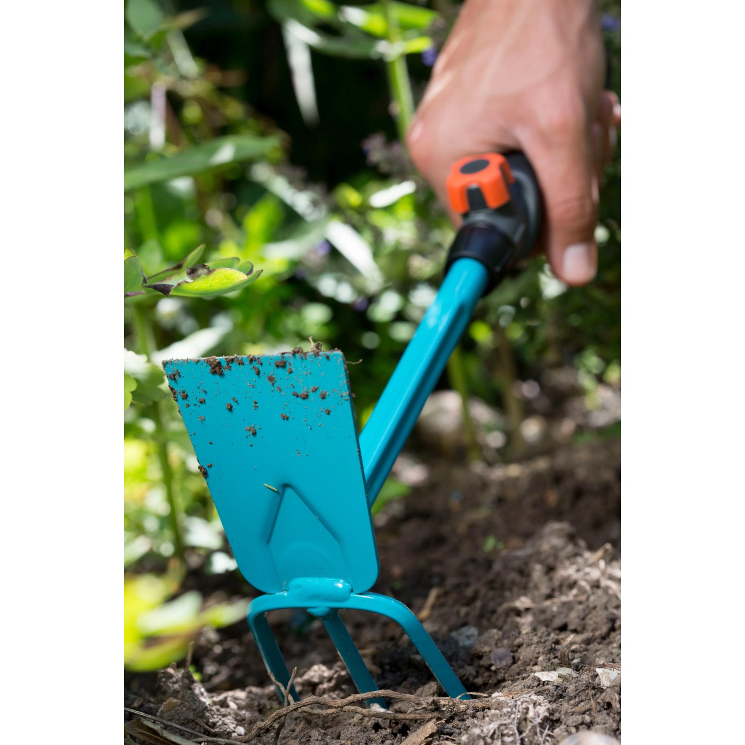 Gardena combisystem Kleinhäckchen mit geradem Blatt und 3 Zinken im Einsatz im Gartenboden.