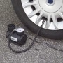 Schwarzer Kompressor mit Manometer pumpt Autoreifen auf. Autoreparatur Zubehör.
